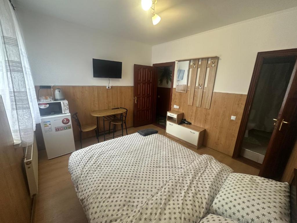 a bedroom with a bed and a kitchen with a table at Бордуляка 11 in Ternopil