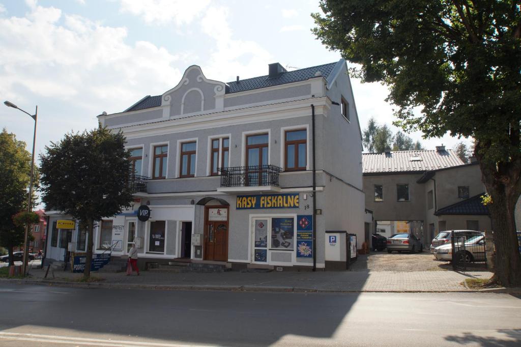 ein großes weißes Gebäude an der Ecke einer Straße in der Unterkunft Apartamenty Ostrowiec - Pokoje Gościnne Centrum in Ostrowiec Świętokrzyski