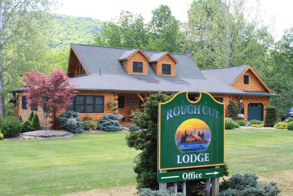 un panneau devant une maison en rondins dans l'établissement Rough Cut Lodge, à Gaines