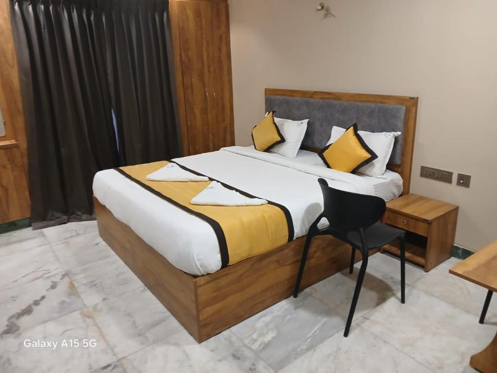 a bedroom with a large bed with yellow and white pillows at Hotel Vimas International in Madurai