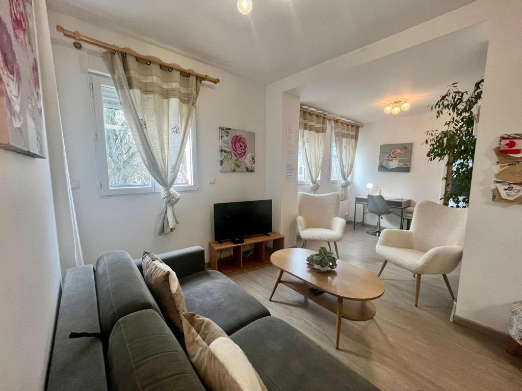 a living room with a couch and a tv at gîte 65 m2 200 m gare t-g-v et fac 400 m centre-ville grand parking 250 places gratuit face au logement in Arras