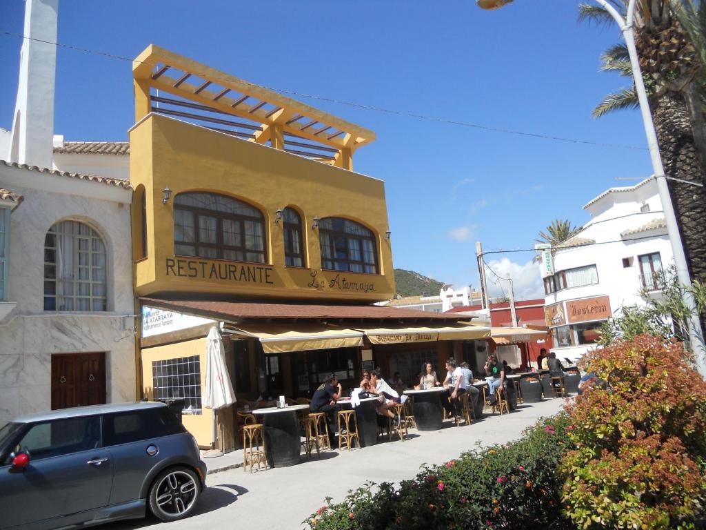 a group of people sitting at tables outside a restaurant at Apartamentos la Atarraya in Zahara de los Atunes