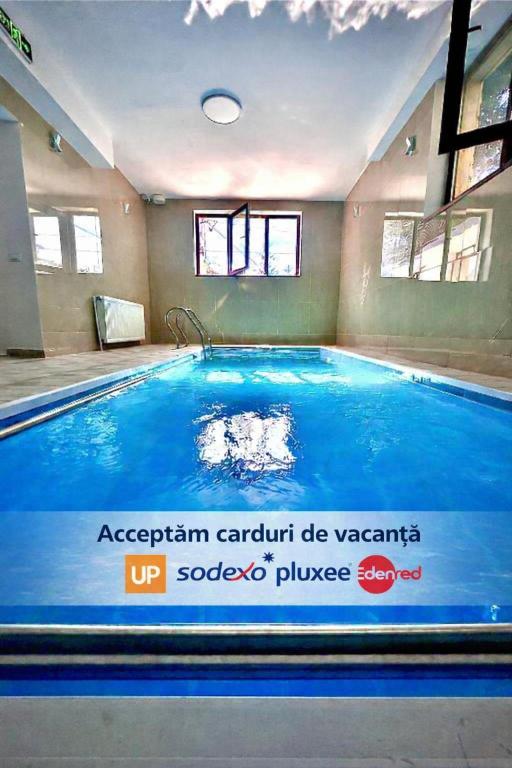 an indoor swimming pool with a large blue pool at Prestige Accommodation & Wellness in Predeal