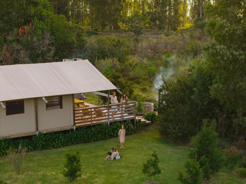 a group of people standing on a deck next to a building at AfriCamps at Oakhurst in Wilderness