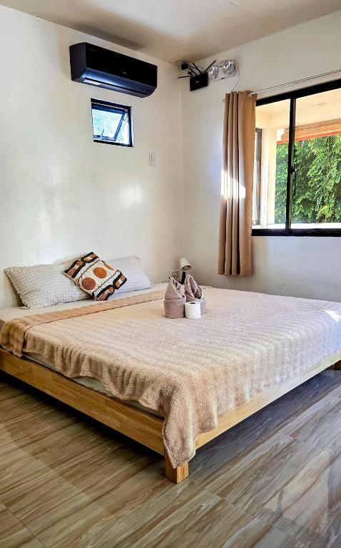 a large bed in a room with a large window at Coconut El Nido in El Nido