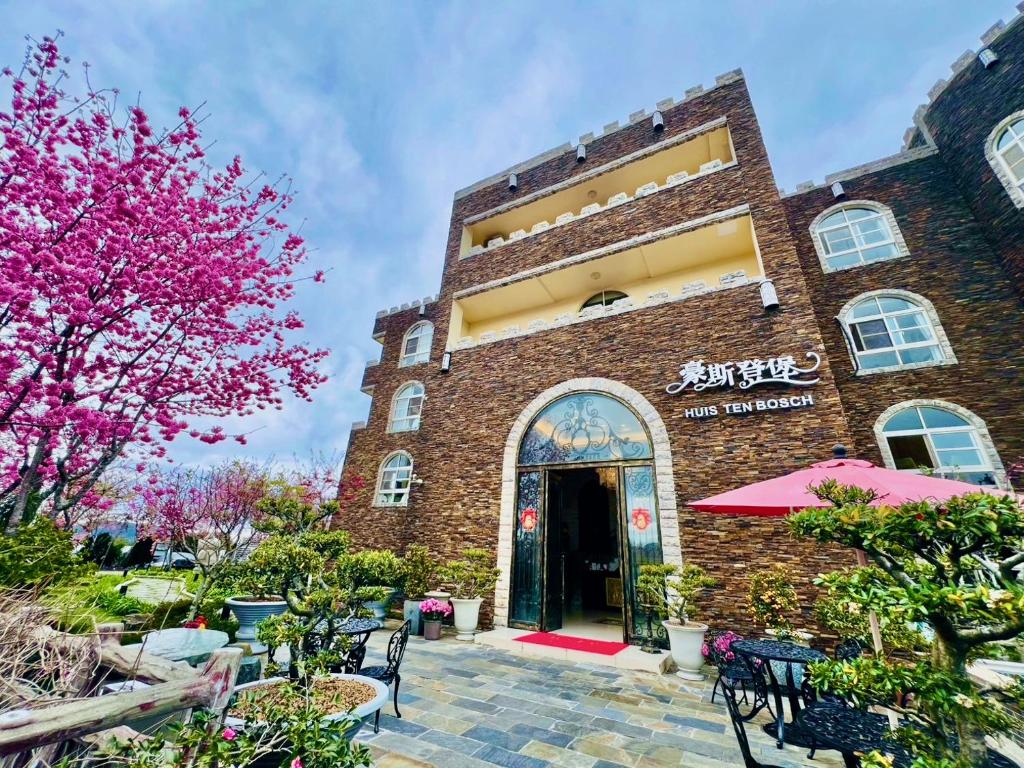 a brick building with tables and chairs in front of it at Huis Ten Bosch in Ren'ai
