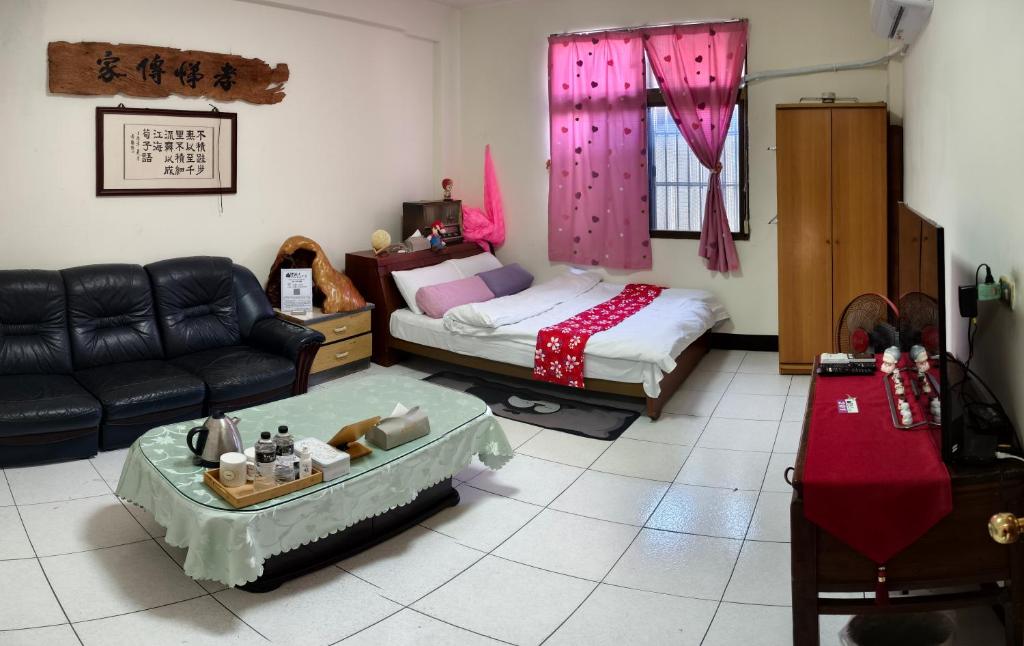 a living room with a bed and a couch at 山頂洞人 in Fengyuan
