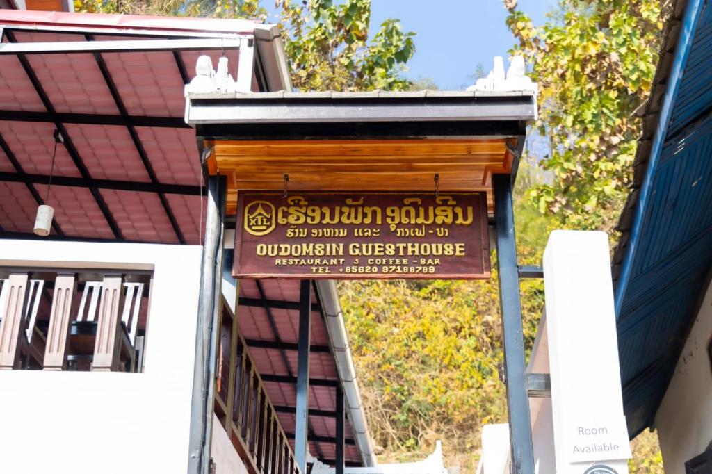 a sign on the side of a building at Oudomsin Guesthouse in Luang Prabang