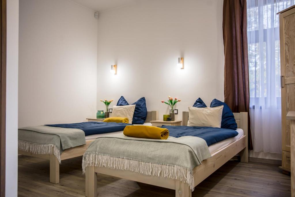 two beds in a room with blue and white at Hont Vendégház in Hont