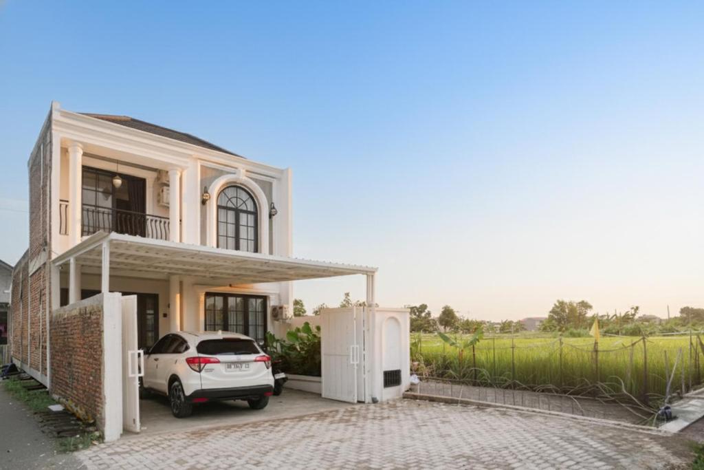 a white car parked in front of a house at Been View Homestay in Adi Sutjipto