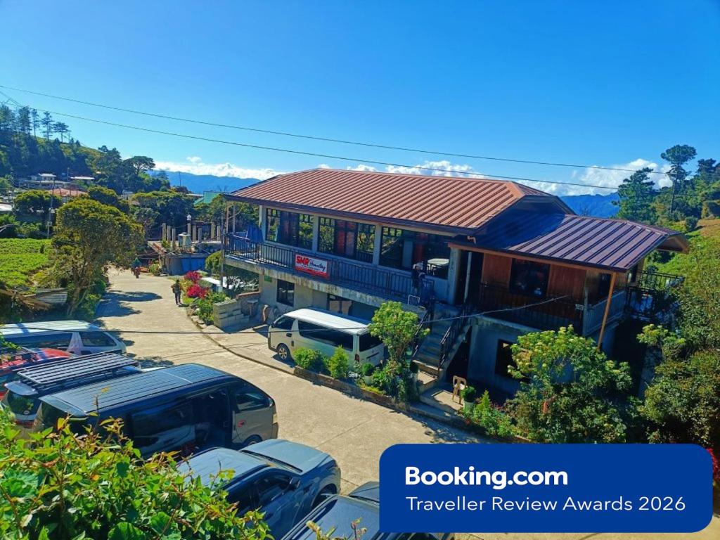 a building with cars parked in a parking lot at Mount Pulag SMR Homestay in Kabayan