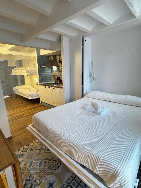 a large white bed in a room with a kitchen at Verdejo - Harbor's Light in Villajoyosa