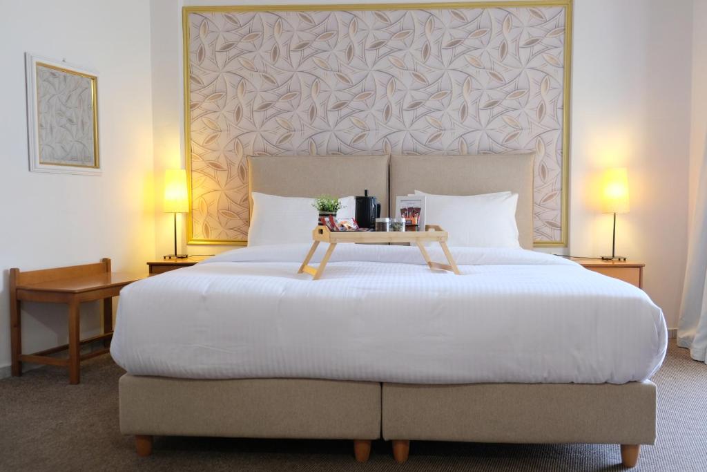 a bedroom with a large bed with a table on it at Eviali Apartments in Límni