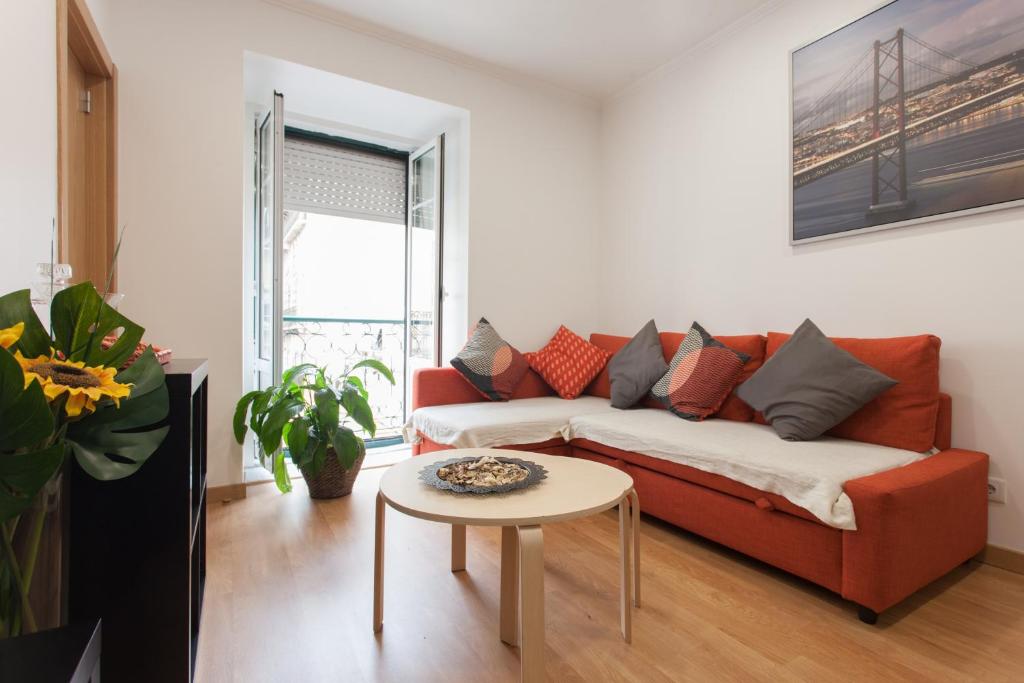 uma sala de estar com um sofá vermelho e uma mesa em Apartments Center Bairro Alto em Lisboa