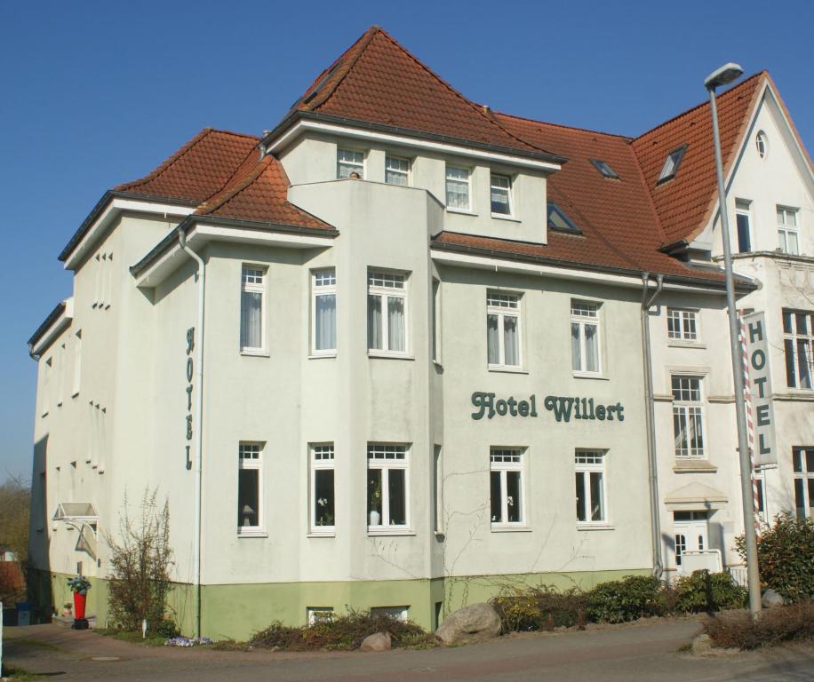 ein großes weißes Gebäude mit rotem Dach in der Unterkunft Hotel Willert in Wismar