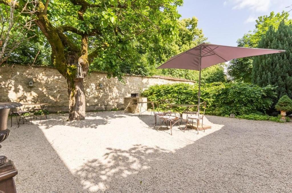 a table and chair with an umbrella in a yard at Le P'tit Clos in Vantoux