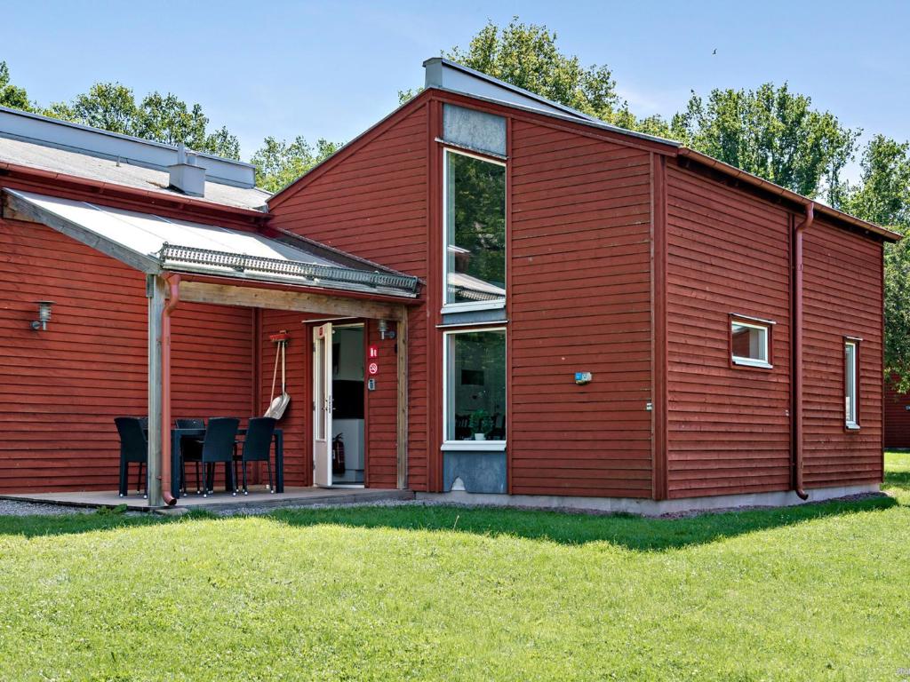 a red house with a table and chairs in front of it at First Camp Västerås-Mälaren in Västerås
