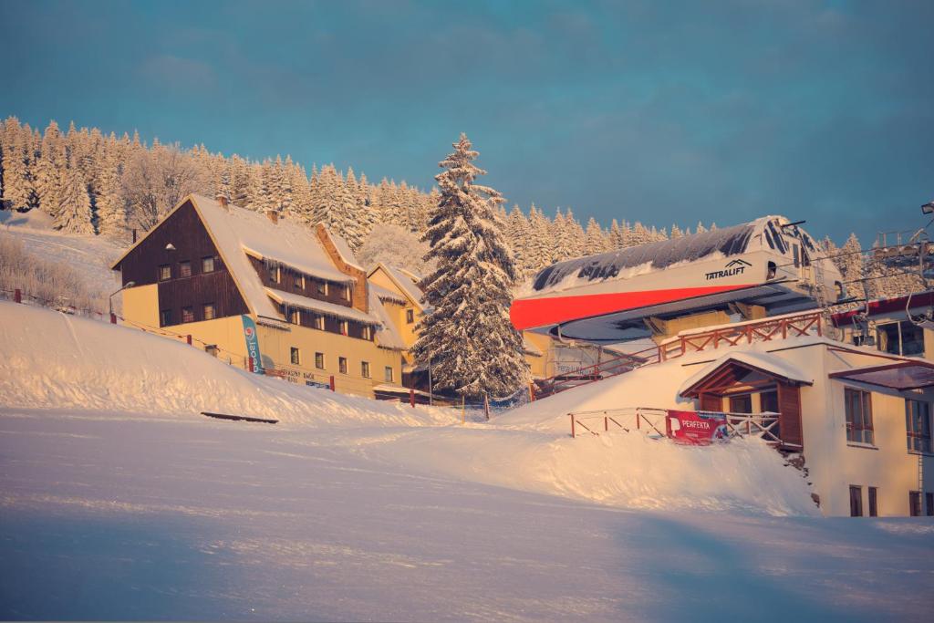 a ski lodge with a train in the snow at Straszny Dwór in Zieleniec