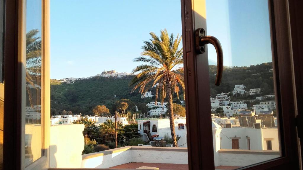a view of a palm tree from a window at En Patmo Holiday Home in Patmos