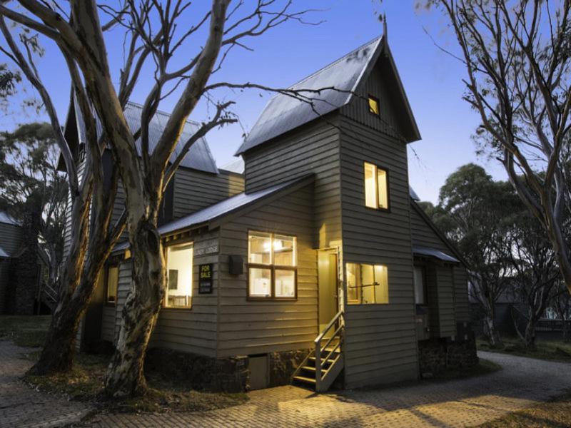 a small house with lights on inside of it at Gundy Lodge in Dinner Plain