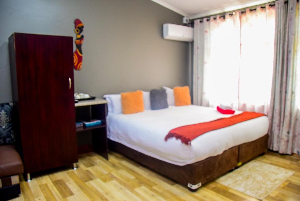a bedroom with a large bed and a window at Umzimkulu Hotel in Umzimkulu