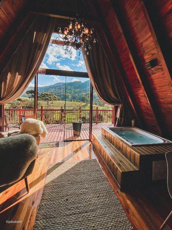 a room with a large window with a hot tub at Estância Nazari in Urubici