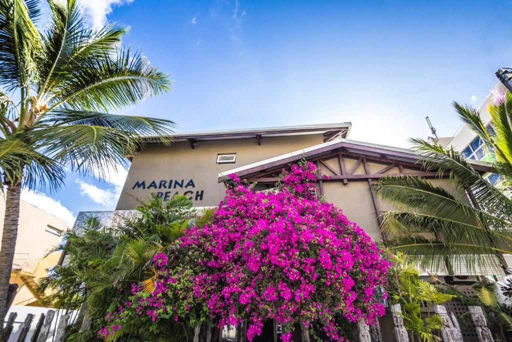 a building with pink flowers in front of it at Résidence Marina Beach in Noumea