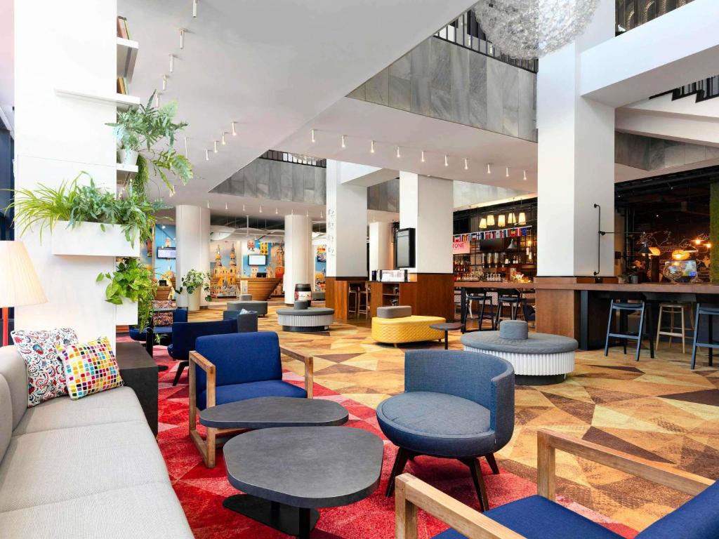 a lobby with chairs and tables and a bar at Novotel Poznan Centrum in Poznań