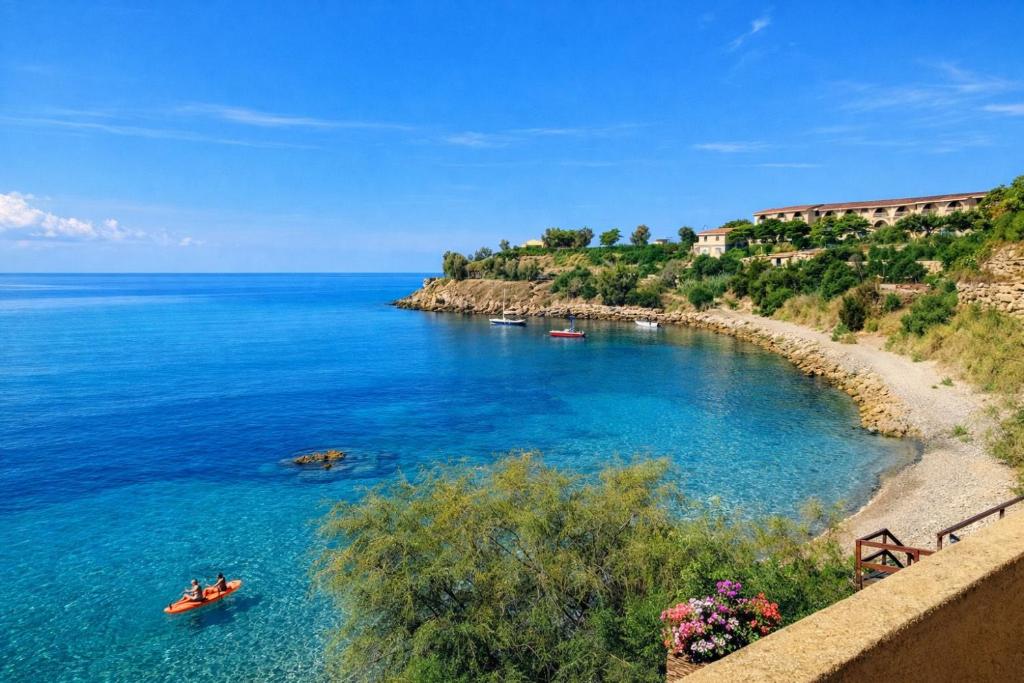 a view of a beach with boats in the water at Cala Greca Case Vacanze in Capo Rizzuto