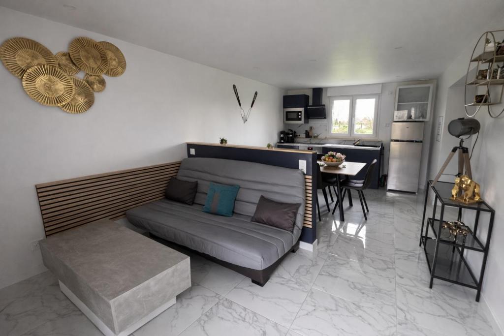 a living room with a couch and a table at Domaine des Moizons, Le Laurier in Villebernier