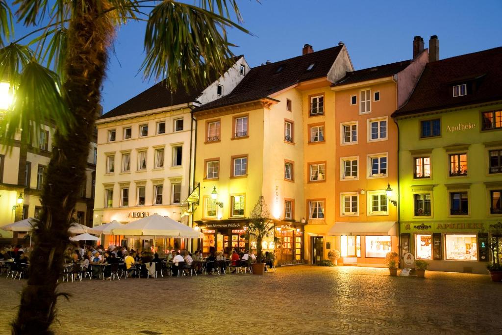 a group of buildings with people sitting at tables in a street at Hotel Zum Schwarzen Walfisch in Bad Säckingen
