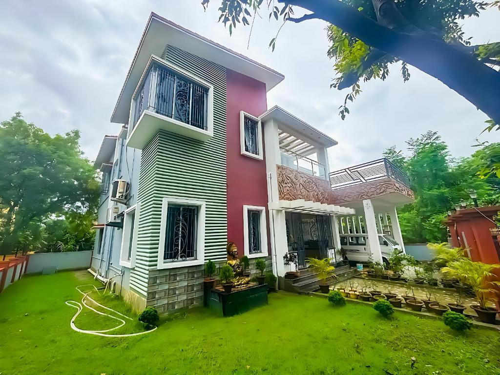 a house with a green lawn in front of it at Swapno Chhobi in Bolpur