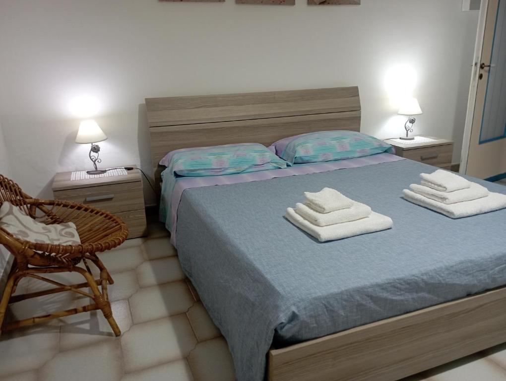 a bedroom with a bed with two towels on it at Villetta Generosa in Torre Lapillo