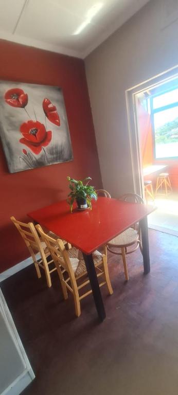 a red table and chairs in a room with a bed at Locsona flat in Margate