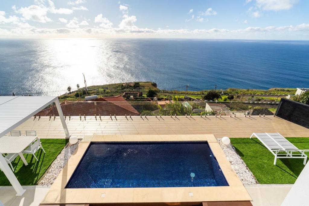a view of the ocean from a house with a swimming pool at GuestReady - The Ocean El Cid in Fajã da Ovelha