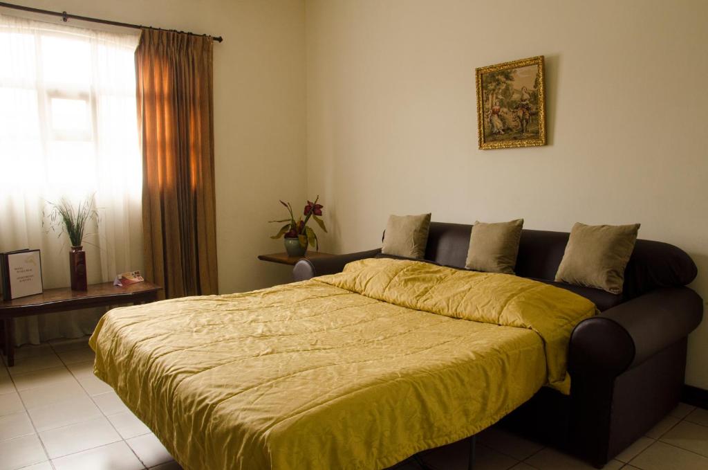 Postel nebo postele na pokoji v ubytování Hotel Plaza Real Suites & Apartments San Jose