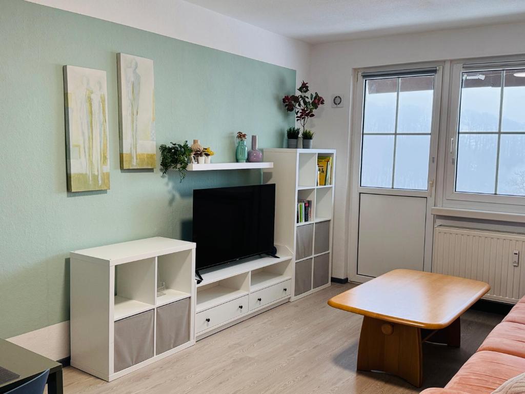 a living room with a tv in a white cabinet at FeWo Einetal 4 im schönen Ostharz in Schielo