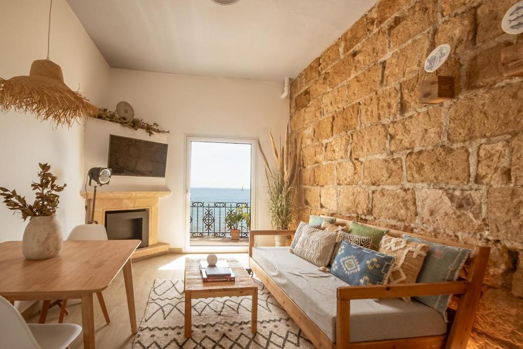 a living room with a couch and a brick wall at The Wave House in Jávea