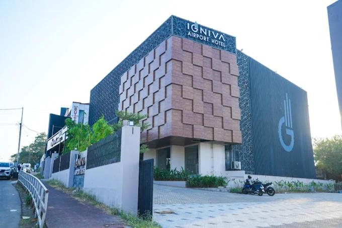 a building with a motorcycle parked in front of it at IGNIVA Airport Hotel in Calicut