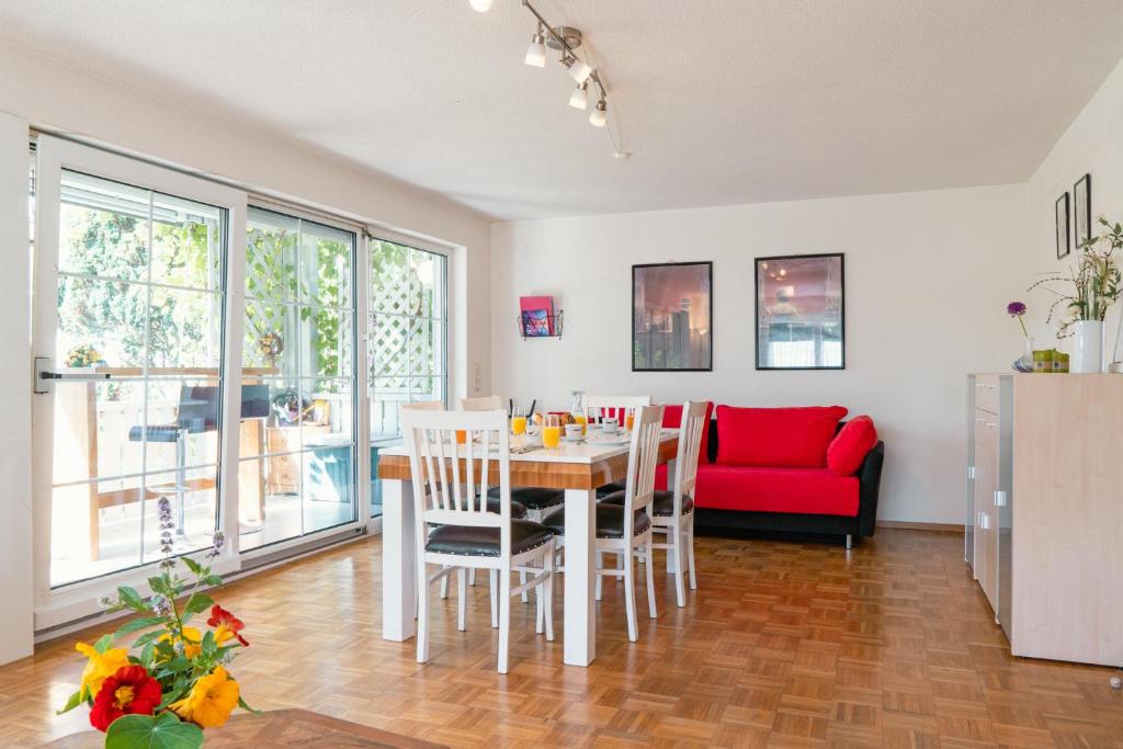 a living room with a table and a red couch at Gardenia-Altach, 2-4 P, Küche, Garten, Terrasse, Parkplatz, Wifi, Ski Stellplatz in Altach