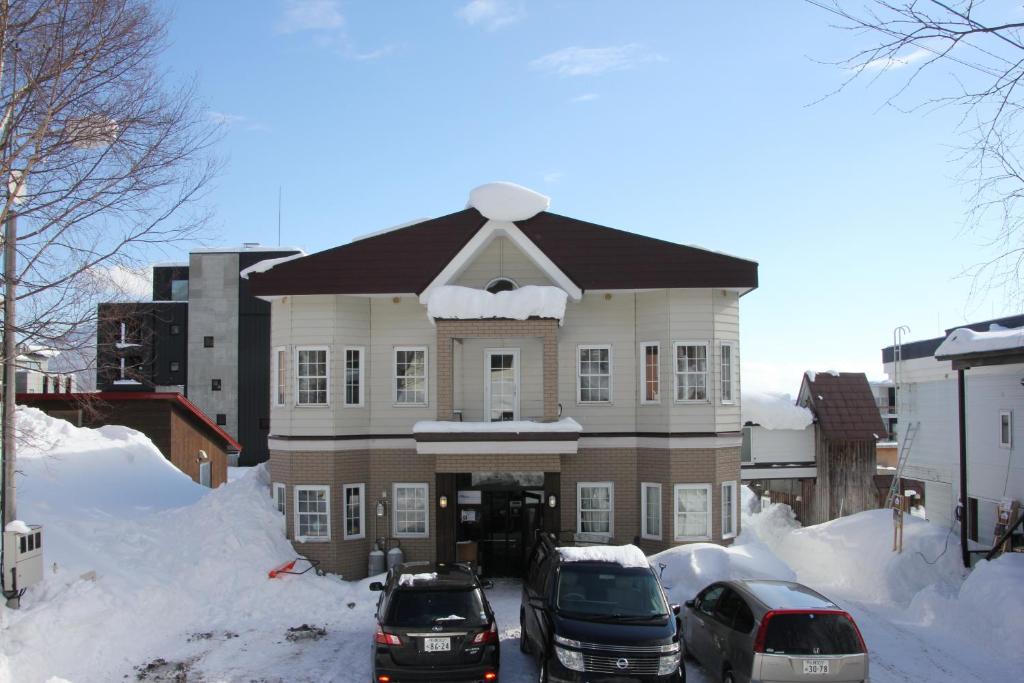 un gran edificio con coches aparcados en la nieve en Absolute Niseko Lodge en Niseko