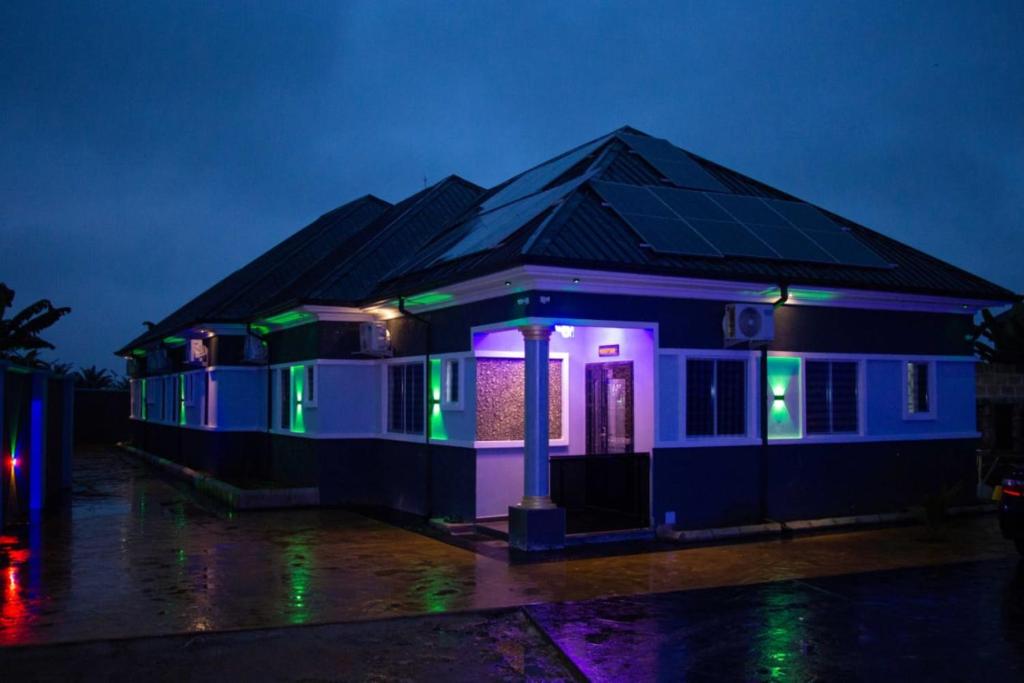 a house lit up with purple and green lights at Mbre Hotel and Resorts in Uyo