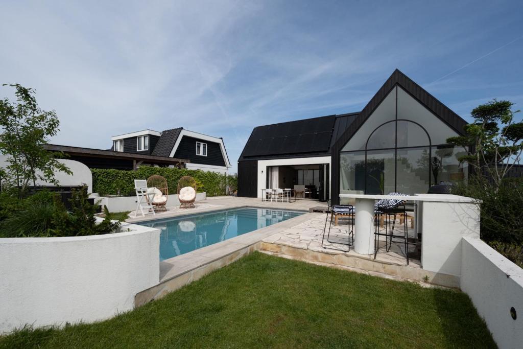 a house with a swimming pool in the yard at 8 persons Wellness Villa Tulpenacker in Roelofarendsveen