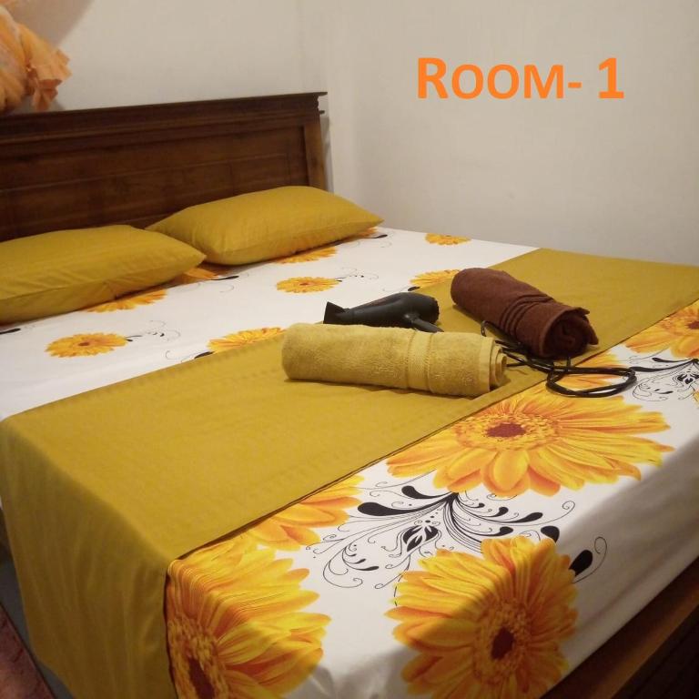 a bed with yellow and white sheets with flowers on it at ALEXANDRA HOME for foreign tourists only in Gampola