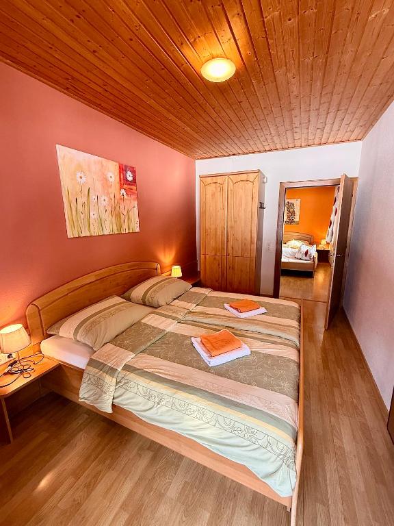 a bedroom with a large bed and a wooden ceiling at Ferienwohnungen Pernull in Waidegg