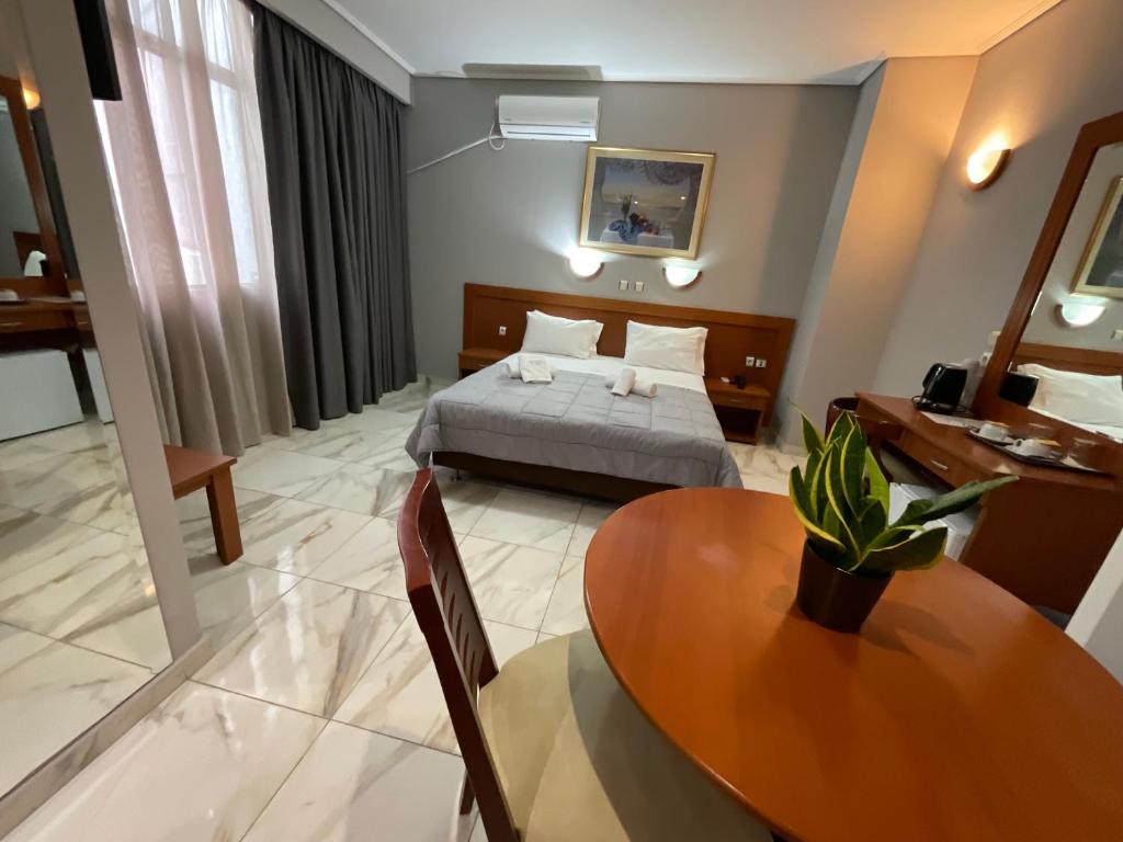 a hotel room with a bed and a table and a room at Piraeus Acropole Hotel in Piraeus