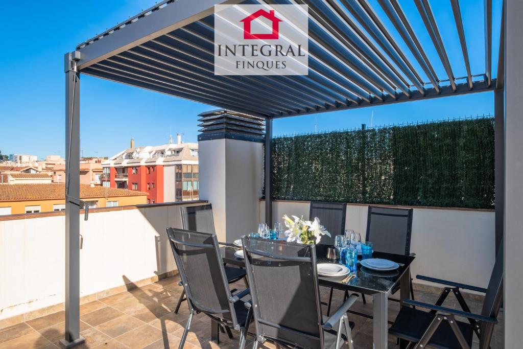 a pergola with a table and chairs on a balcony at Golden Hour Palamós in Palamós