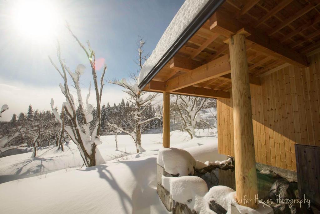 drewniany domek ze śniegiem na ziemi w obiekcie Morino Lodge - Myoko w mieście Myoko