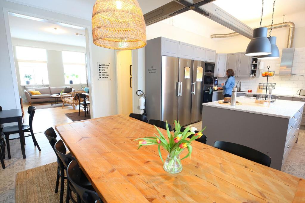 a kitchen and dining room with a wooden table with a vase at Stationshuset bed and breakfast i Ed in Ed