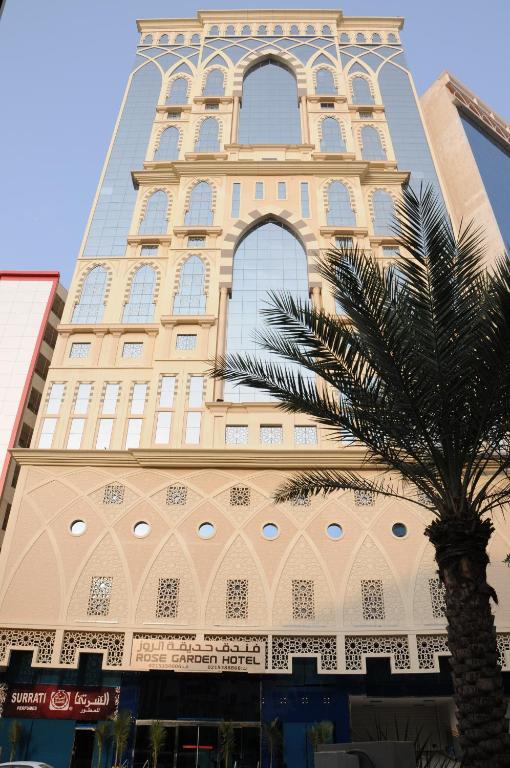 a tall building with a palm tree in front of it at حديقة الروز in Al Masfalah